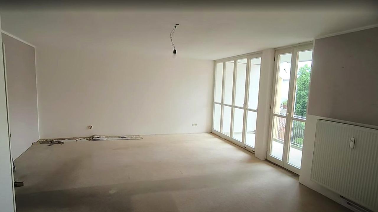Wohnzimmer vorher: leerer Rohbauzustand mit altem Estrich